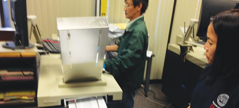 Fourteen machines inside the county Registrar of Voters take stacks of ballots and spit them out rapid-fire for results.