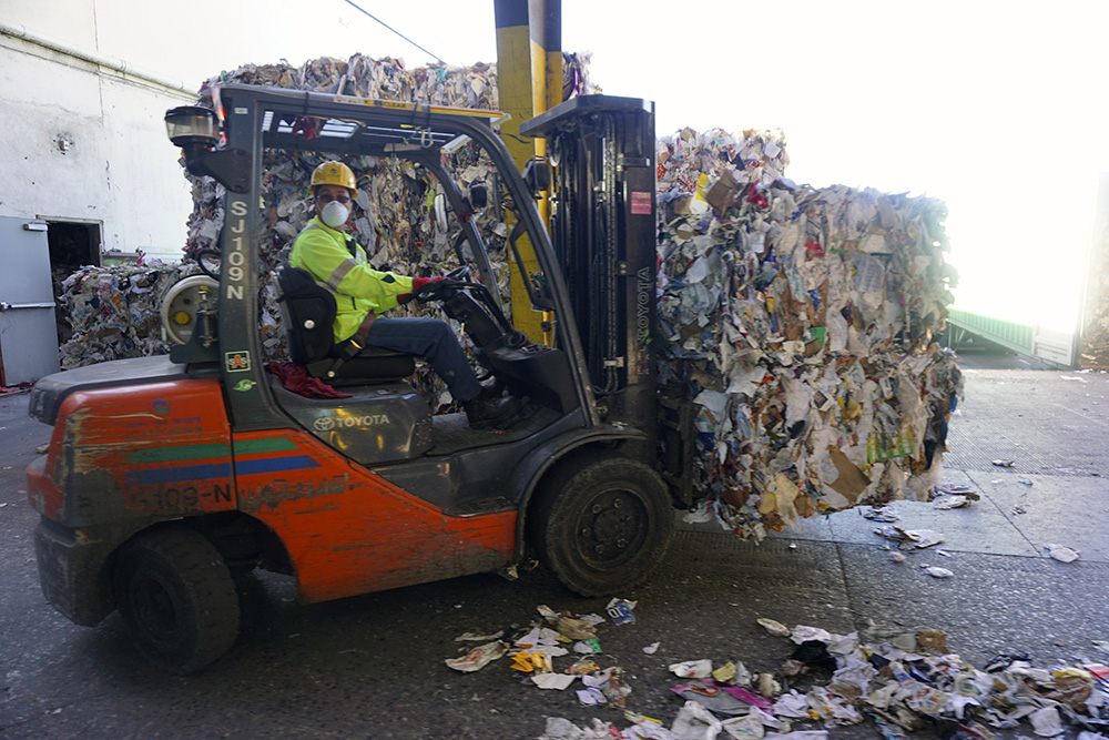 A CWS worker moves bales of recyclables, which end up getting shipped to China.